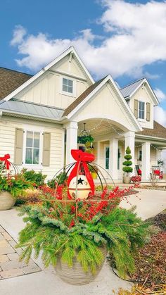 a house with christmas decorations in the front yard and landscaping around it, on a sunny day