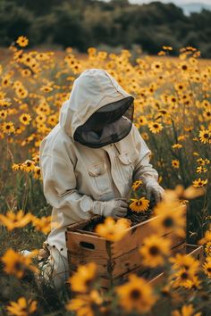 a person in a bee suit picking up some flowers