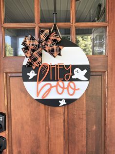 a door with a sign that says dirty boo on it and a bow hanging from the front