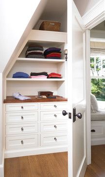 an open closet with white drawers and shelves