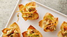 small appetizers with various toppings on a white platter, ready to be eaten