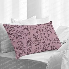 a pink pillow sitting on top of a bed