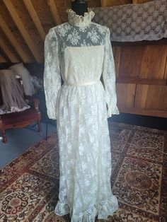 Here is an interesting dress presented by Victoria Royal "made in British Crown Colony, Hong Kong" in 1968.  Ivory chantilly lace over silk organza over lightweight taffeta lining. The silk layer has frayed a bit and needs to be trimmed and rehemmed, if it bothers you. It can not be seen from the outside of the garment. I love the ruffled lace stand-up collar that ties in a bow at the nape. The spaghetti strap top is not attached to the last for nice movement. Natural waist with a detachable satin crepe tie belt which can be switched out or tied in the front...whatever you want! Long-sleeved, sheer lace with a ruffled cuff. The hem is finished off with a 4" lace flounce.  This dress has no train. Measurements (tagged a vintage size 12) = Bust- 36" Waist- 26" Hips- 37" Length from shoulder Vintage Lace Gowns, Interesting Dress, Spaghetti Strap Top, Chantilly Lace, Silk Organza, Strap Top, Lace Gown, Vintage Lace, Sheer Lace