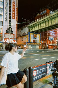 a woman sitting on a bench in front of a street