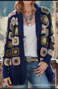 a woman wearing a blue crochet cardigan and jeans