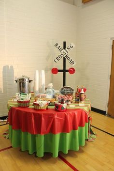 a table covered in candy and candies with a cross on the wall behind it