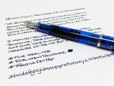 a fountain pen sitting on top of a paper with some writing in the bottom corner