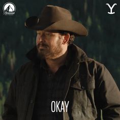 a man wearing a cowboy hat with the words okay in front of him and trees behind him