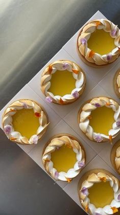 six small pies with yellow and white frosting