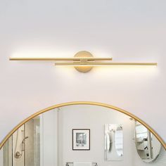 a bathroom with a sink, mirror and lights on the wall above it is shown