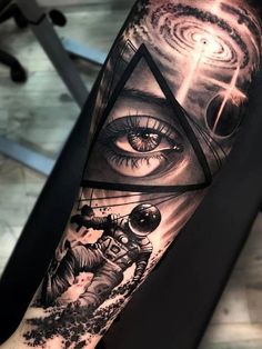 an all seeing eye tattoo on the arm with space and astronaut in front of it