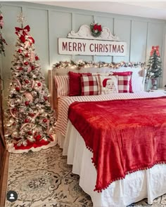 a bedroom decorated for christmas with red and white bedding, plaid pillows, and trees