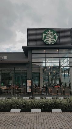 the front of a starbucks coffee shop on a cloudy day