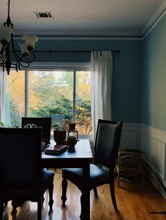 a dinning room table and chairs in front of a window