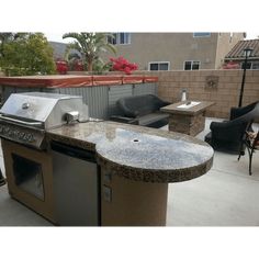 an outdoor kitchen with grill and seating area