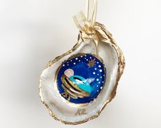 an ornament in the shape of a seashell with gold and blue decorations