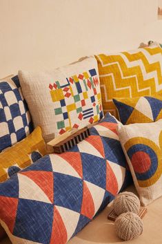 colorful pillows and balls of yarn on a couch