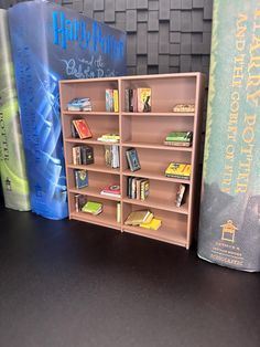 a book shelf with several books on it and harry potter's house in the background