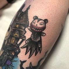 a person with a tattoo on their arm has a drawing of a cartoon character in the background