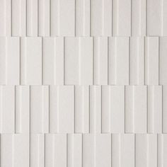 a white tile wall with vertical lines on it's sides and diagonals in the middle