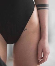 a woman in a black swimsuit with tattoos on her arm