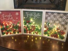 three christmas cards on a table with lights