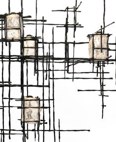 an artistic sculpture made out of sticks and glass cubes with lights on each side