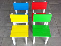 four colorful chairs sitting on top of a tiled floor