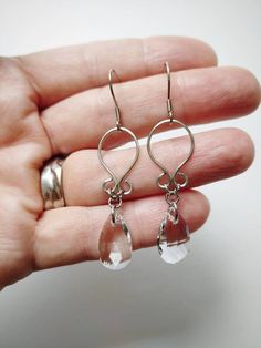 "Simple, yet flattering, wire wrapped earrings with multifaceted teardrop glass beads. Made with 100% stainless steel wire and earring hooks. They hang approximately 1.75\" down from earring hook. Earrings will come on an earring card with plastic earring backs. *Note: this listing is for one pair of earrings. Please choose color below. All my jewelry is handmade, and made with patience, care and love. In the unlikely event that it needs to be repaired, I'll do it free of charge." Wire Wrapped Earrings Simple, Silver Wire-wrapped Teardrop Earrings, Metal Teardrop Earrings With French Hook, Minimalist Wire Wrapped Crystal Drop Earrings, Adjustable Wire Wrapped Teardrop Crystal Earrings, Elegant Metal Teardrop Earrings Wire Wrapped, Elegant Metal Teardrop Earrings With Wire Wrapped Detail, Adjustable Long Drop Crystal Earrings, Elegant Metal Wire Wrapped Teardrop Earrings