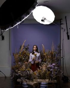 a woman standing in front of a flower arrangement