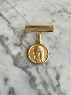 a gold medal with a woman's head on it sitting on a marble surface