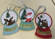 three christmas ornaments are hanging on a table