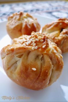 three pastries on a plate with sesame seeds