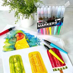 some crayons and markers are sitting on a table next to an art project