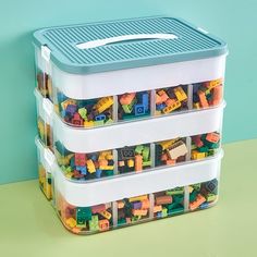 three plastic storage containers with legos in them