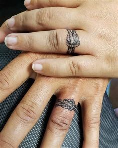 two people with matching rings on their fingers, one has a knot tattooed on the middle finger