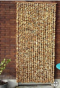 a wall made out of wine corks on the side of a brick building next to a potted plant