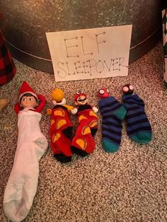 five sockies are laying on the floor next to a sign that says elf sleepover