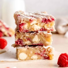 three raspberry white chocolate bars stacked on top of each other next to some raspberries