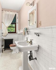 a bathroom with pink walls and white fixtures