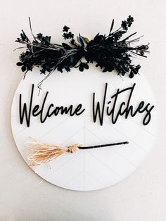 a welcome witches sign hanging on the wall