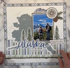 someone holding up a card with the word alaska on it and two people standing in front of them