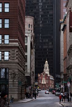 a city street with tall buildings in the background