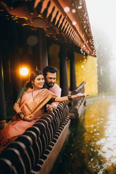 a man and woman sitting next to each other near water