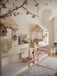 a child's bedroom with bunk beds and stuffed animals on the shelves, in front of a cherry blossom tree