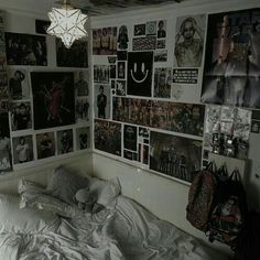 a bedroom with many pictures on the wall and a white bed in front of it