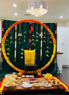 a table topped with lots of food next to a green curtain