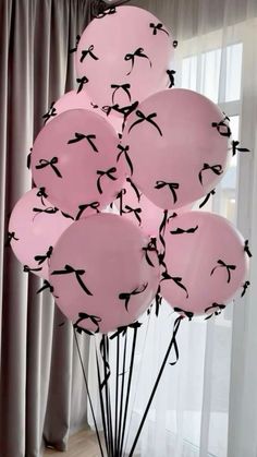 a bunch of pink balloons with black birds on them