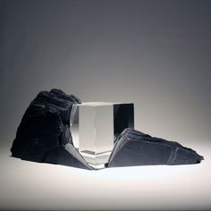 a black and white object sitting on top of a table next to a large rock