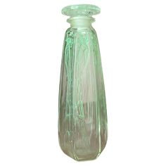 a green glass vase sitting on top of a table